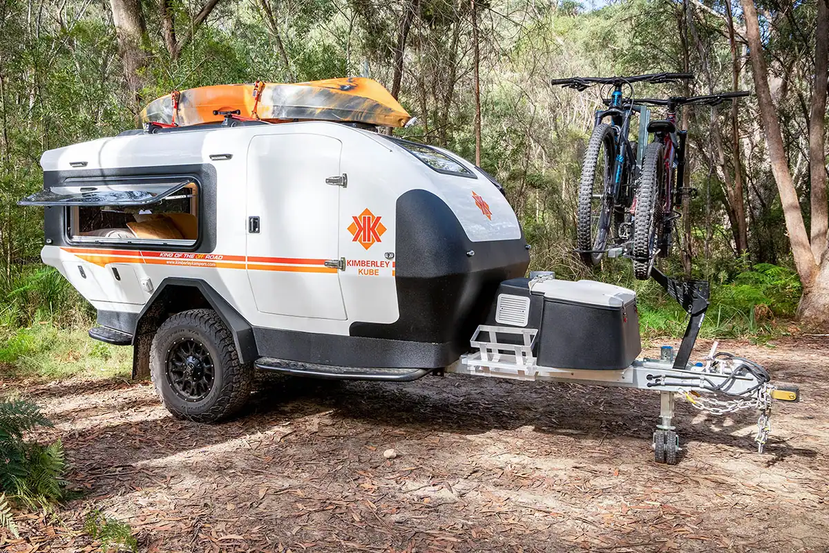Kube Teardrop Camper with iSi Bicycle Rack Australian Bush Teardrop camper with iSi bicycle rack attached, parked outdoors with Australian bush background.