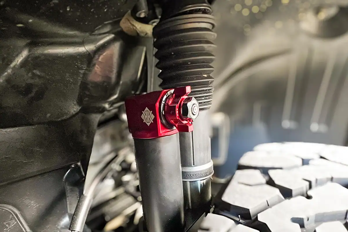 Kimberley Kampers Offroad Motorhome Adjustable Suspension System Close-up of Kimberley Kampers offroad motorhome adjustable suspension system, showing the red anodised height-adjustable shock absorber top.